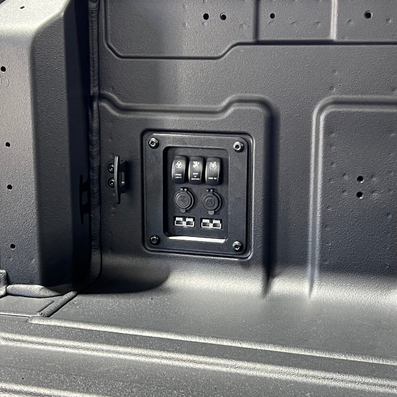 Close-up of a black accessory panel on a grey vehicle ute tub interior